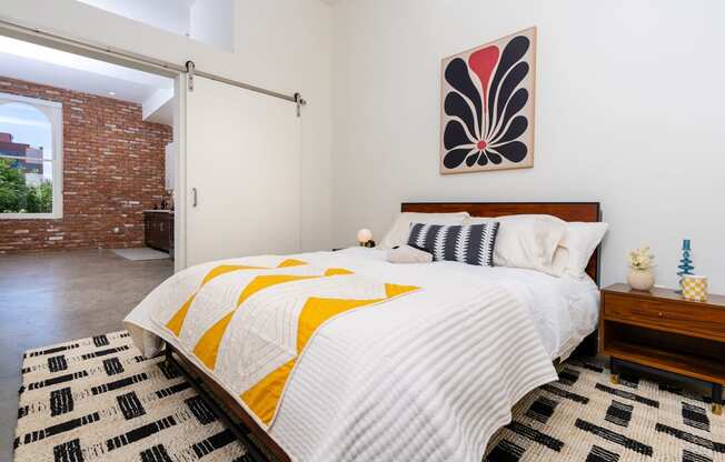 a bedroom with a bed and a red brick wall