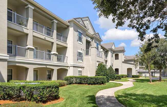 Apartment complex with a walkway in front.