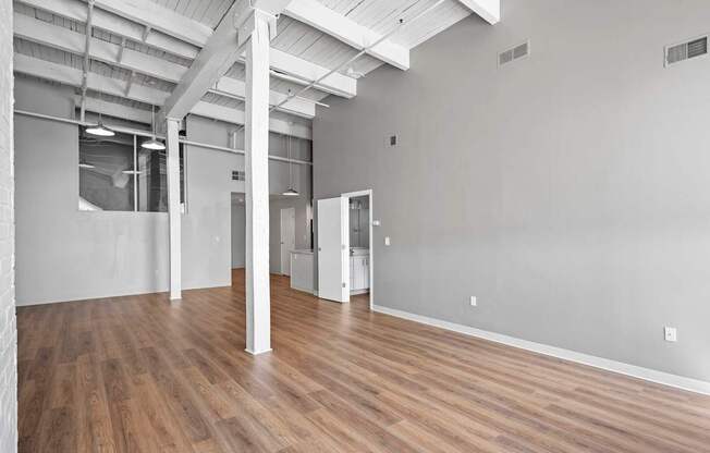 A large empty room with wooden floors and white walls.