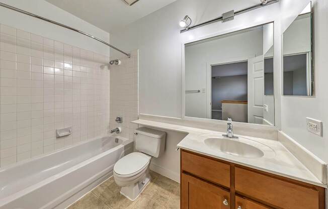 A white bathroom with a toilet, sink, and bathtub.