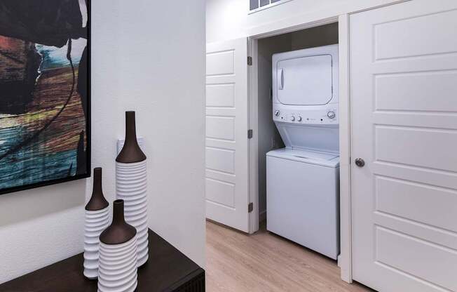 a white washer and dryer in a room with a door to a bathroom