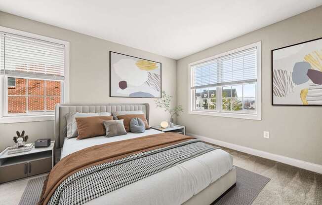 A bedroom with a large bed and two framed artworks on the wall.