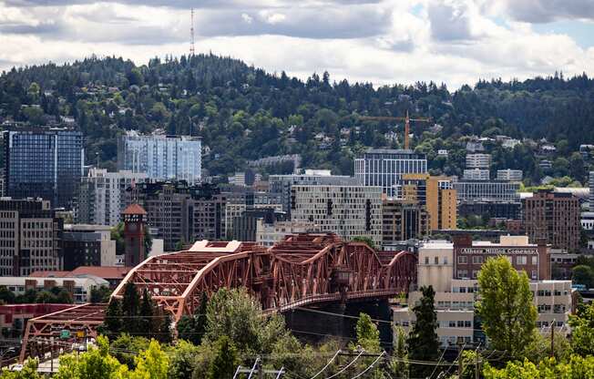 a bridge over a city with mountains in the background at Analog PDX Apartments, Portland, OR