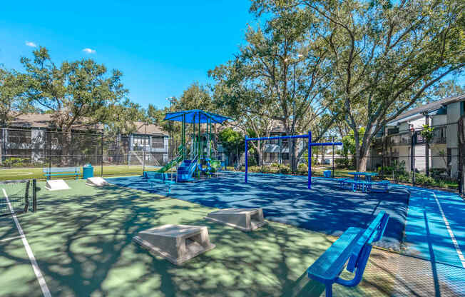Community playground, benches, picnic tables and cornhole boards at Huntington Place in Sarasota, Florida.
