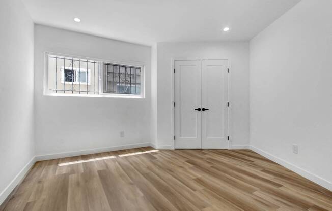 a living room with white walls and a window and a door