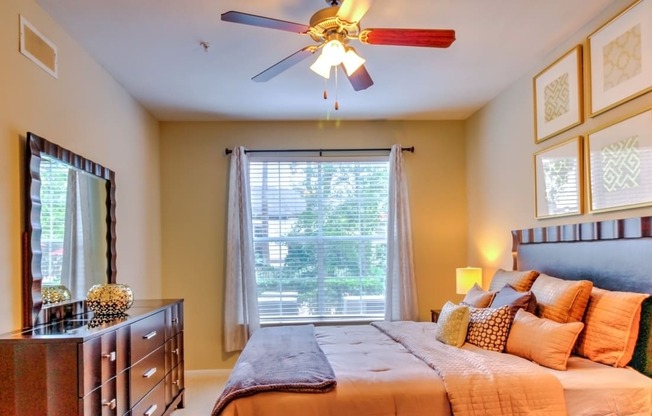 a bedroom with a large bed and a ceiling fan