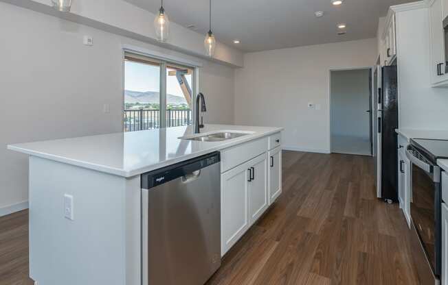 an open kitchen with a large island and a stainless steel dishwasher at The Crossings at Windsong, Prescott Valley, AZ