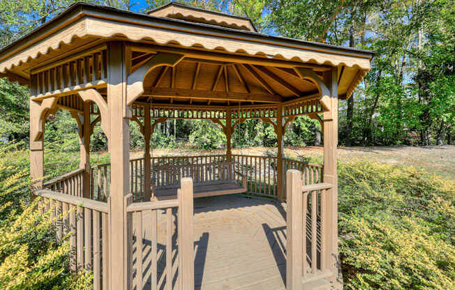 a gazebo with a wooden deck in a park