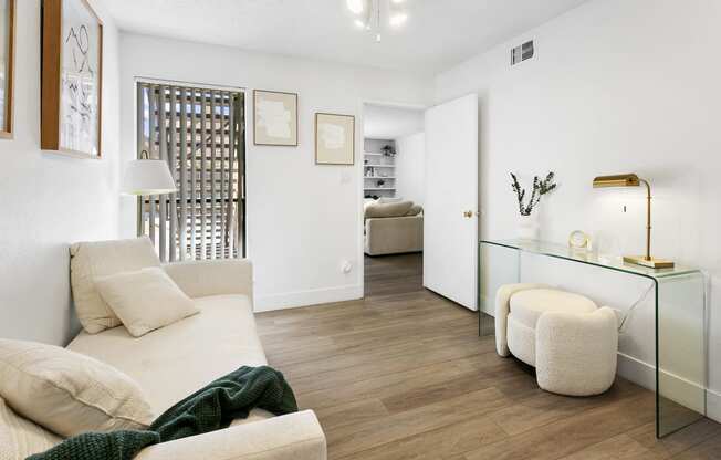 a living room with a white couch and a glass table