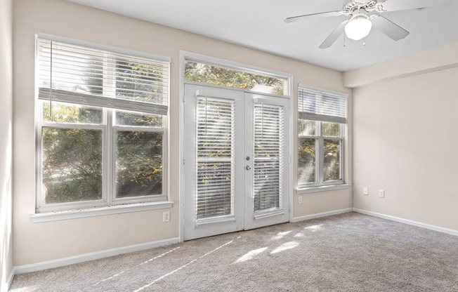 The living room windows of Ten05 West Trade Apartments, which allow for natural light. There is a large door leading to a patio.