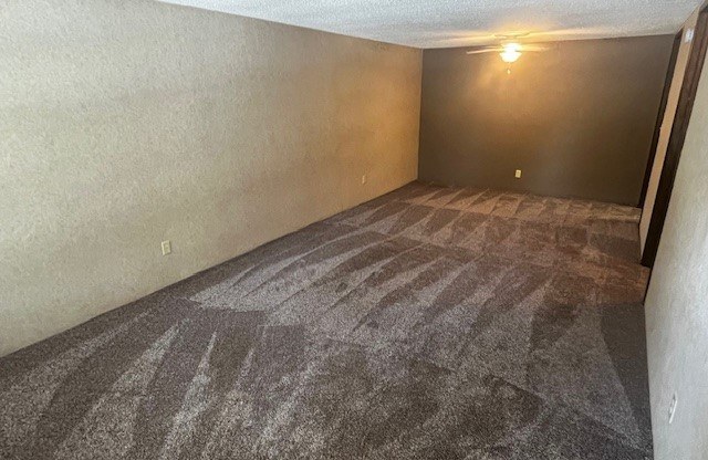 an empty living room with a carpeted floor