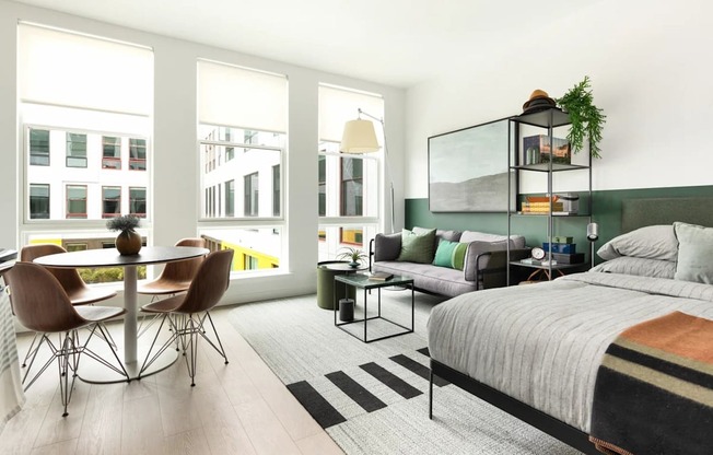 A modern bedroom with a large bed and a dining table with chairs.