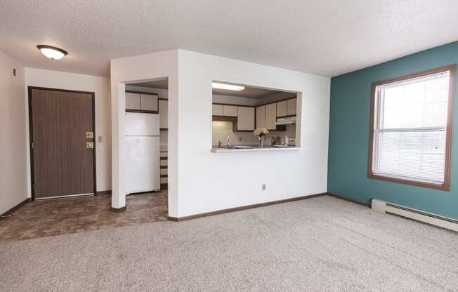 Grand Forks Primrose Apartments. An empty living room with a kitchen in the background