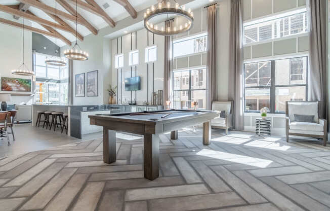 a pool table in a living room with large windows