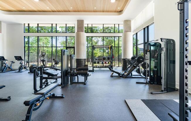 Light-filled fitness studio with strength equipment, open floor space, and natural light supporting focused workouts and daily training routines.