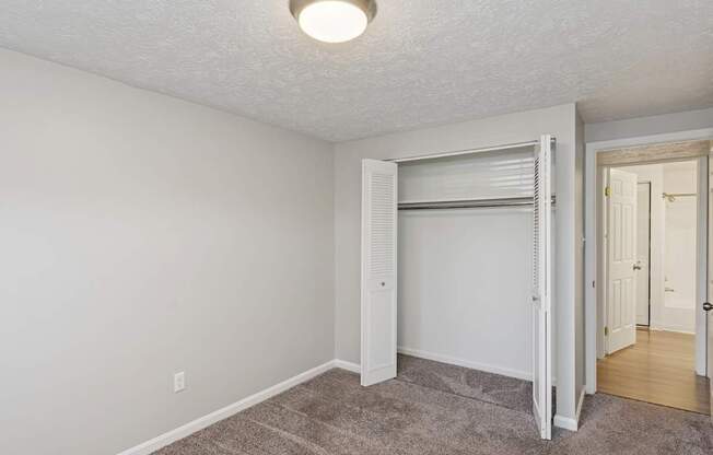 A room with a carpeted floor and a sliding door.