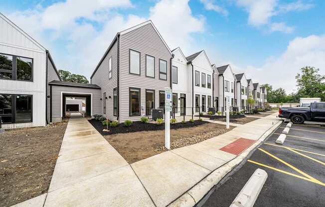 A row of modern houses with a truck parked in the driveway.