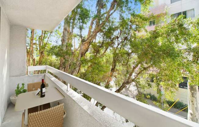 a balcony with a table and a bottle of wine on it