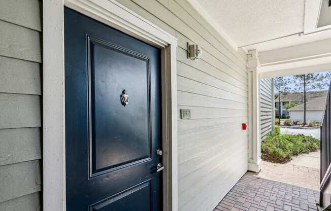 A dark blue door going into a Royal Plan floor plan type at Oakleaf Plantation apartments in Jacksonville, FL.
