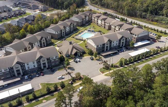 A bird's eye view of a residential complex with multiple houses and a pool.