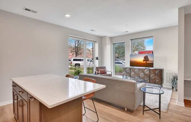 a kitchen with an island and a living room with a couch and a coffee table