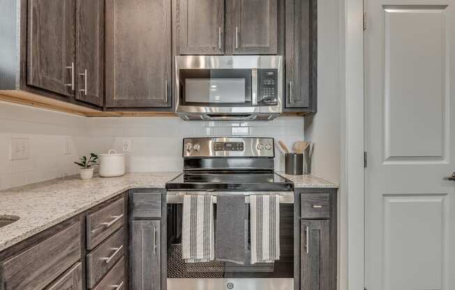 Kitchen with Dark Brown Cabinetry and Stainless Steel Appliances