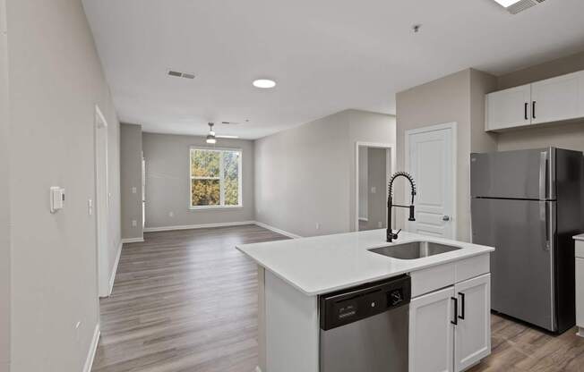 Flatiron West Trade Apartments unstaged model unit with quartz countertops, stainless steel appliances and a large living room.