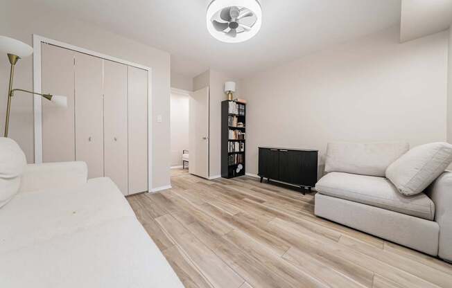 A living room with a white couch and a black radiator.