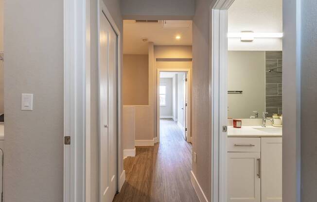 A long hallway with white walls and wood floors.