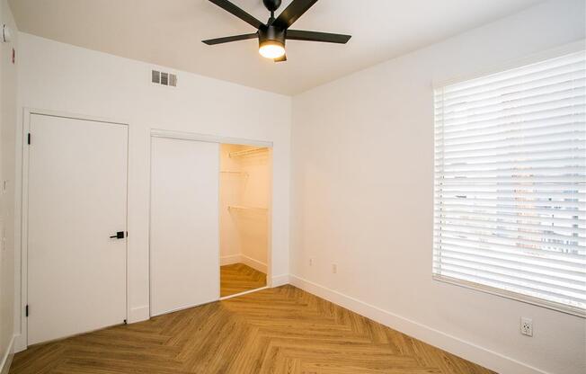 a bedroom with a ceiling fan and a closet