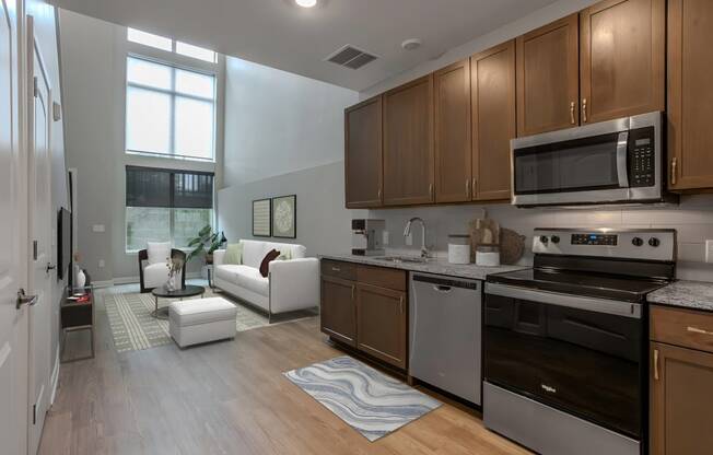 a kitchen and living room with wood floors and stainless steel appliances