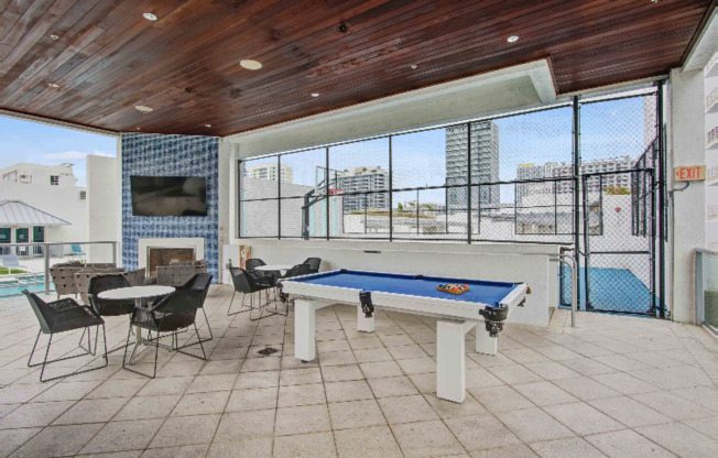 An outdoor patio with a pool table outside apartments near Miami Beach.