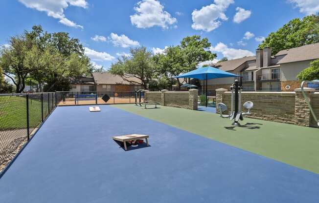 a dog park with a trampoline and agility course at the whispering winds apartments in pear
