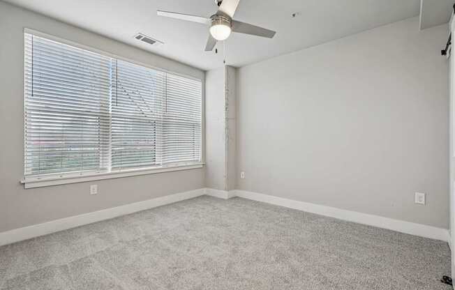 a large bedroom with windows and a fan. A, high ceiling, apartment that has two floors, is a modern loft, and in atlanta