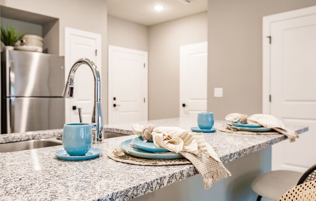 a kitchen with a sink and a counter with plates and napkins