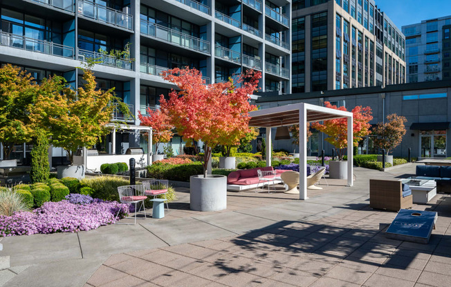 an outdoor area with benches and trees in front of a building