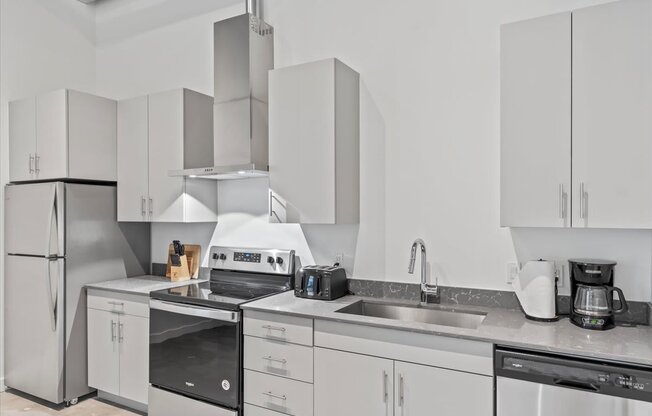 A modern kitchen with white cabinets and stainless steel appliances.