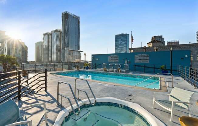 a pool on the roof of a building with a city in the background