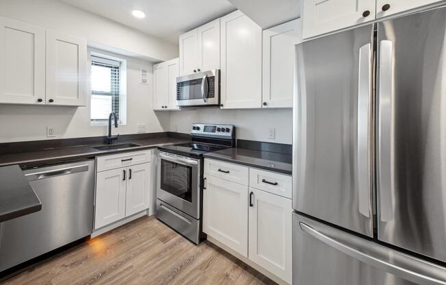 a kitchen with stainless steel appliances and white cabinets