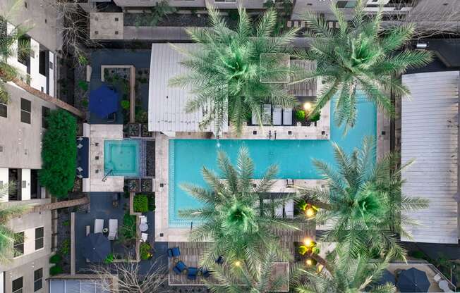 a building with a pool and palm trees