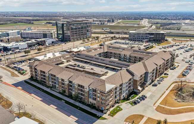 A large building complex with a parking lot in front.