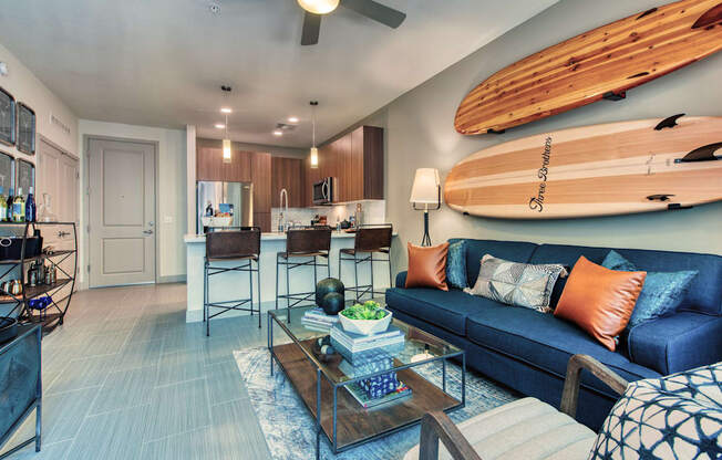 A living room with a blue couch and a wooden coffee table.