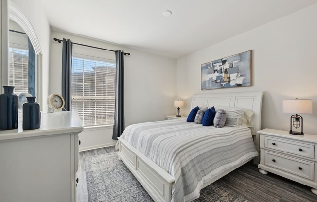 a white bedroom with a bed and a window