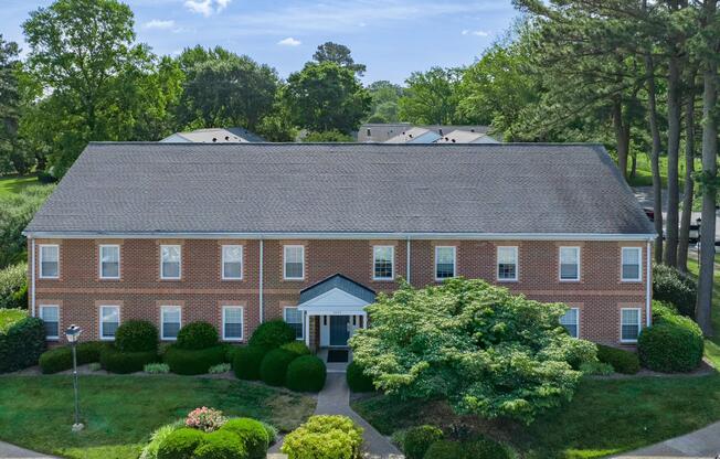 a large brick building with grass in front of a house