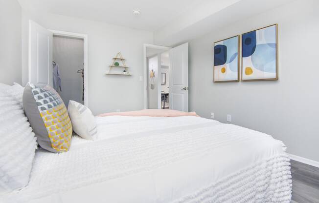 a bedroom with a large bed and two paintings on the wall