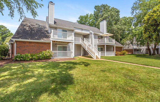 A house with a red brick chimney and a white porch.