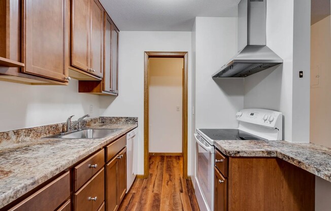 Welcome to Central Lakes of Uptown, where modern living meets comfort. This stylish kitchen features rich wood cabinetry and sleek granite countertops, perfect for culinary creations. Elevate your lifestyle today and schedule a tour!