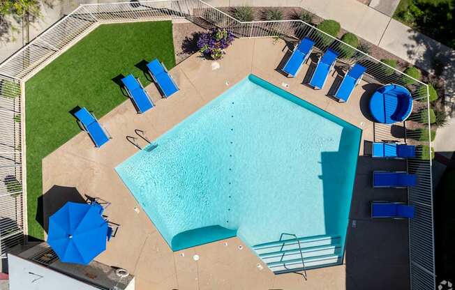 An aerial view of a pool surrounded by blue lounge chairs.