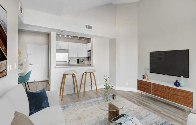 A modern living room with a white couch and a bar area.