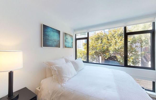 a bedroom with a large bed and a large window